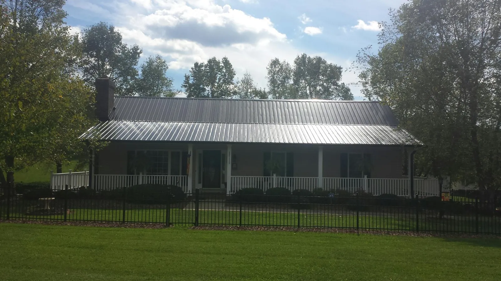 Gray metal roof on a brick ranch with a full width front porch in Waverly